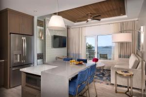 a kitchen and living room with a table with blue chairs at Limetree Beach Resort by Club Wyndham in Raphune +71 photos