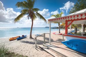 - une plage avec une maison, un palmier et l'océan dans l'établissement Limetree Beach Resort by Club Wyndham, à Raphune