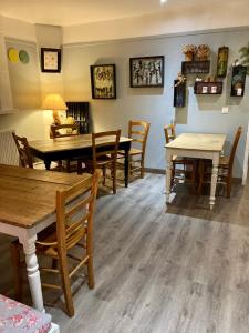 a dining room with wooden tables and chairs at La Niche in Richebourg