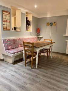 a living room with a couch and a table and chairs at La Niche in Richebourg