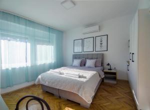 ein Schlafzimmer mit einem großen Bett und einem Fenster in der Unterkunft The House Apartments & Guest Rooms in Ohrid