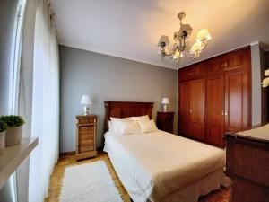 Schlafzimmer mit einem Bett und einem Kronleuchter in der Unterkunft APARTAMENTO ALFICA VUT-981-AS in Llanes