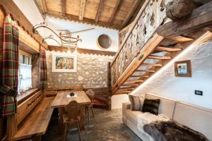a room with a table and a couch and stairs at Chalet Catinaccio Rosengarten 56 in Pozza di Fassa