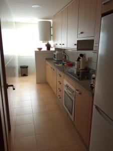 una cucina con lavandino e piano cottura forno superiore di CORMORANT SUITE, sea terrace & pools a La Manga del Mar Menor