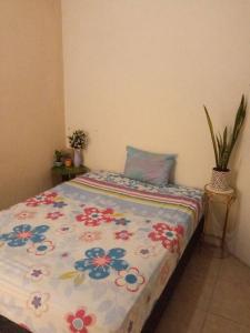 a bedroom with a bed with a floral comforter at La Casa Del Pinito in Sonsonate