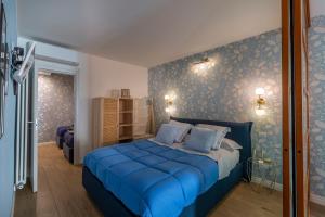a bedroom with a blue bed in a room at The Cozy Loft, un angolo alla moda nel cuore di Verona in Verona