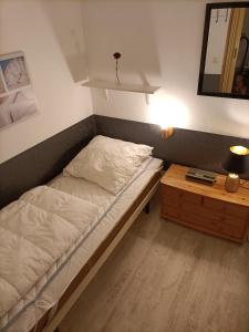 um quarto com uma cama e uma mesa de cabeceira com um espelho em Ferienwohnung Isabell em Hahnenklee-Bockswiese