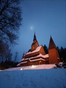 uma igreja coberta de neve à noite em Ferienwohnung Isabell em Hahnenklee-Bockswiese