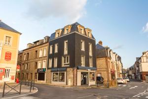 un edificio alto negro en una calle de la ciudad en la belle vue le diamant des yeux mer et golf front mer, en Étretat