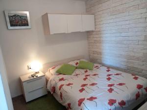 Un dormitorio con una cama con flores rojas. en Apartment Vrančić, en Šibenik
