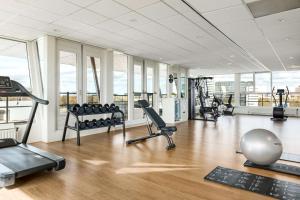 een fitnessruimte met loopbanden en fitnessapparatuur in een gebouw bij NH Zoetermeer Hotel in Zoetermeer