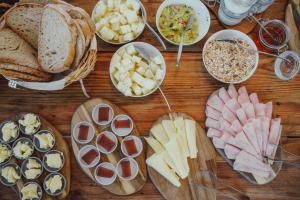a wooden table topped with lots of different types of food at MUTE Hostel Porto Covo in Porto Covo