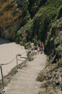 a group of people walking down a path on a mountain at MUTE Hostel Porto Covo in Porto Covo
