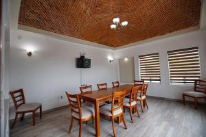 a dining room with a wooden table and chairs at Hotel la Cuesta Toscana in Bernal