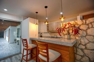 a kitchen with a counter with chairs and a vase at Hotel la Cuesta Toscana in Bernal