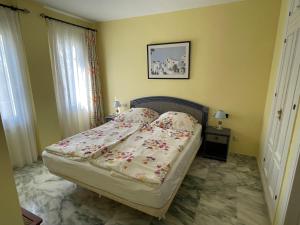 - une chambre avec un lit dans une pièce aux murs jaunes dans l'établissement El Lobo de Mar Estepona, à Estepona