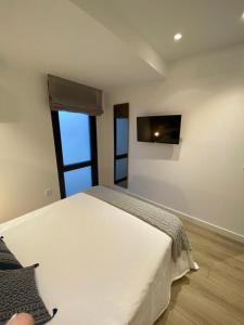 um quarto com uma cama e uma televisão na parede em LINEROS SUITE em Córdoba