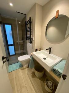 W łazience znajduje się umywalka, toaleta i lustro. w obiekcie LINEROS SUITE w Kordobie
