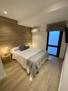 a bedroom with a large bed and a large window at LINEROS SUITE in Córdoba