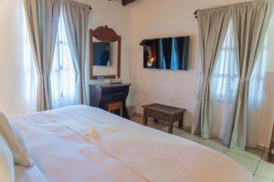 a bedroom with a bed and a sink and a mirror at Casa Graciela Hotel Pátzcuaro in Pátzcuaro