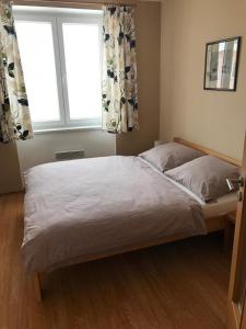 a large bed in a bedroom with two windows at Apartmán Abertamy in Abertamy