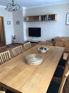 a wooden dining room table with chairs and a television at Apartmán Abertamy in Abertamy