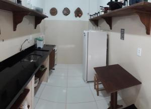 a kitchen with a refrigerator and a table in it at Pousada Pico Da Vila in Vale do Capao