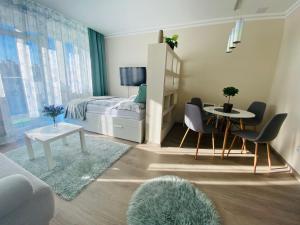 1 dormitorio con 1 cama, mesa y sillas en Zrinyi Central Apartman with free parking en Nyíregyháza