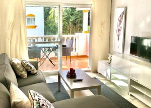 salon z kanapą i telewizorem w obiekcie Residencial las Flores Marbella w Marbelli