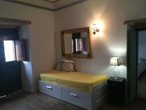 アルパリョンにあるCasa das Andorinhasのベッドルーム1室(壁に鏡付きのベッド1台付)