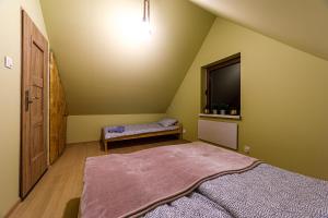 a attic room with a bed and a tv at Domki W Zaciszu Gomólnika in Głuszyca