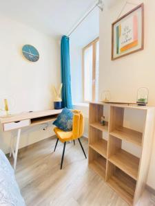 una camera da letto con scrivania e sedia gialla di appartement chic a Laon