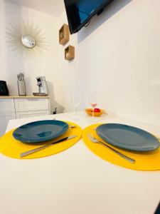 un tavolo con due piatti gialli e bicchieri da vino di appartement chic a Laon