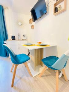 una camera con una scrivania e due sedie blu di appartement chic a Laon