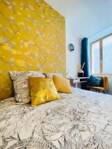 - une chambre dotée d'un lit avec un mur jaune dans l'établissement appartement chic, à Laon
