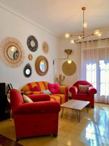 a living room with two red couches and mirrors at Alojamiento estilo Boho con mucho encanto in Ponferrada