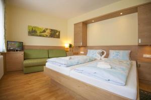 a bedroom with a large bed and a couch at Kaiser-Franz in Bad Hofgastein
