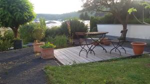 una terraza de madera con mesa de picnic y algunas plantas en Domizil Koblenz, en Coblenza