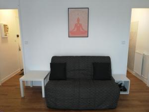 a living room with a couch and a table at Chaleureux studio tout confort in Orléans