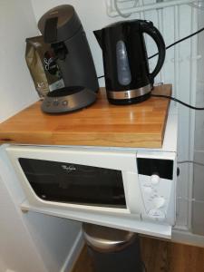 a microwave sitting on top of a counter with a coffee maker at Chaleureux studio tout confort in Orléans