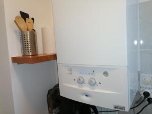 a white stove in a kitchen with a shelf at Chaleureux studio tout confort in Orléans