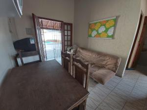 een woonkamer met een tafel en een bank bij 0006.03 - Maranduba - Chalé - 1 Dorm - 5 Pess - 3 Quadras Do Mar - Piscina Coletiva - WIFI in Ubatuba