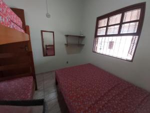 een slaapkamer met een rood bed en een raam bij 0006.02 - Maranduba - Chalé - 1 Dorm - 5 Pess - 3 Quadras Do Mar - Piscina Coletiva - WIFI in Ubatuba