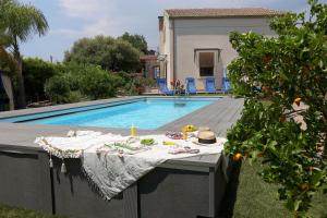 a table sitting next to a swimming pool at Casa delle foglie in San Giovanni la Punta