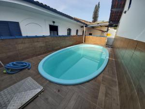 een grote blauwe kuip op het terras van een huis bij 0005.02 - Maranduba - Chalé - 1 Dorm - 6 Pess - 3 Quadras Do Mar - Piscina Coletiva - WIFI - Ar Condicionado in Ubatuba