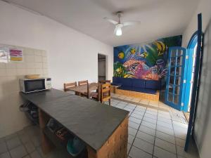 een keuken met een aanrecht en een schilderij aan de muur bij 0005.02 - Maranduba - Chalé - 1 Dorm - 6 Pess - 3 Quadras Do Mar - Piscina Coletiva - WIFI - Ar Condicionado in Ubatuba
