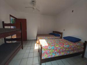 een slaapkamer met twee bedden en een tafel erin bij 0005.02 - Maranduba - Chalé - 1 Dorm - 6 Pess - 3 Quadras Do Mar - Piscina Coletiva - WIFI - Ar Condicionado in Ubatuba