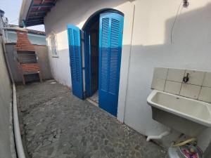 een badkamer met blauwe deuren en een wastafel naast een gebouw bij 0005.02 - Maranduba - Chalé - 1 Dorm - 6 Pess - 3 Quadras Do Mar - Piscina Coletiva - WIFI - Ar Condicionado in Ubatuba +11 foto's