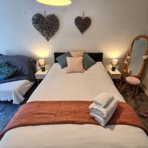 a bedroom with a bed with two hearts on the wall at Old Road Cottage Pet Friendly Outdoors Beaches in Neath