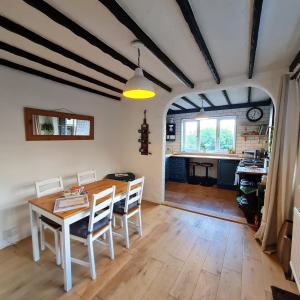 a kitchen and dining room with a table and chairs at Old Road Cottage Pet Friendly Outdoors Beaches in Neath
